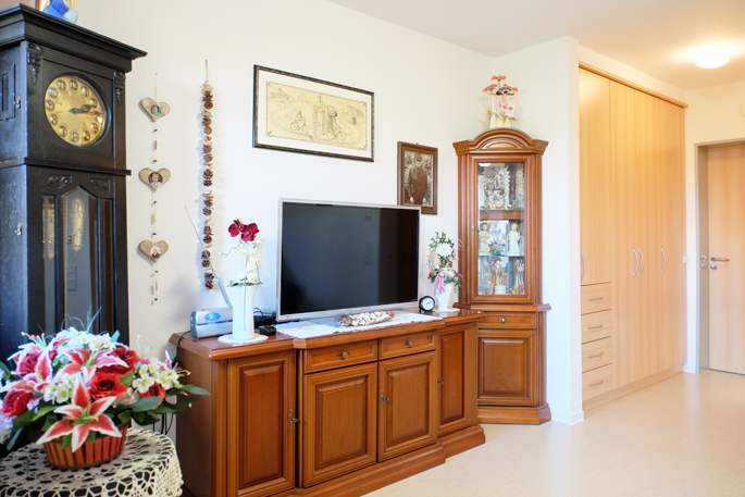 Zimmer mit Schrank, Fernseher und großer Uhr